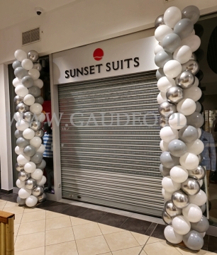 Kolumny balonowe w Lesznie jako dekoracja wejścia do salonu Sunset Suits.